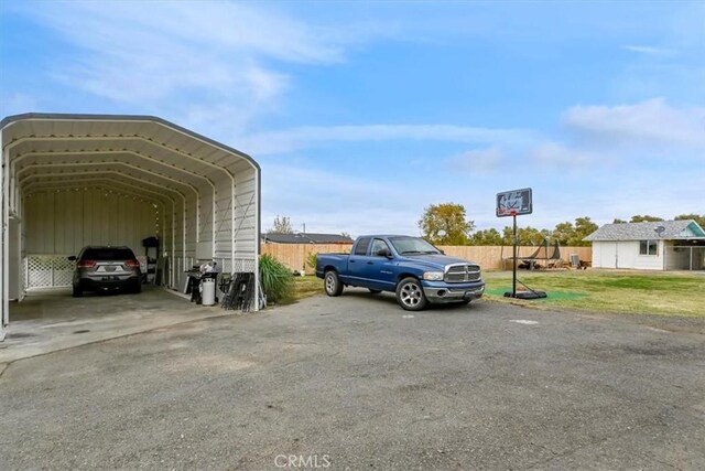 view of parking / parking lot with a lawn and a carport