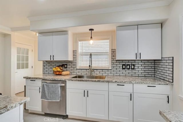 kitchen with decorative light fixtures, stainless steel dishwasher, white cabinetry, and sink