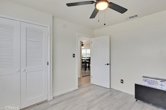 unfurnished bedroom featuring a closet, ceiling fan, and light wood-type flooring