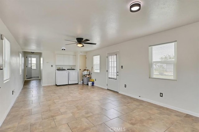 unfurnished living room featuring washer and clothes dryer, ceiling fan, and a healthy amount of sunlight