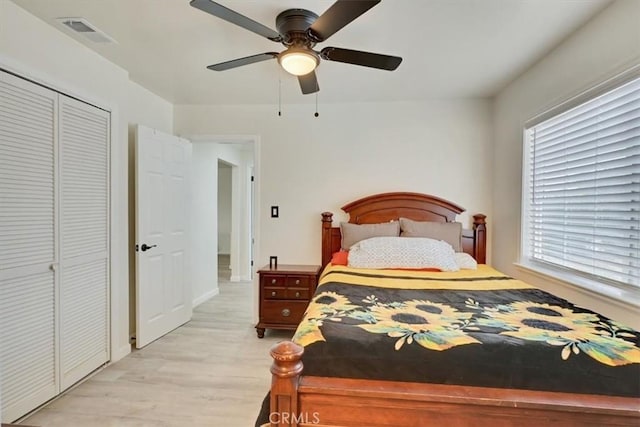 bedroom with multiple windows, a closet, ceiling fan, and light hardwood / wood-style flooring