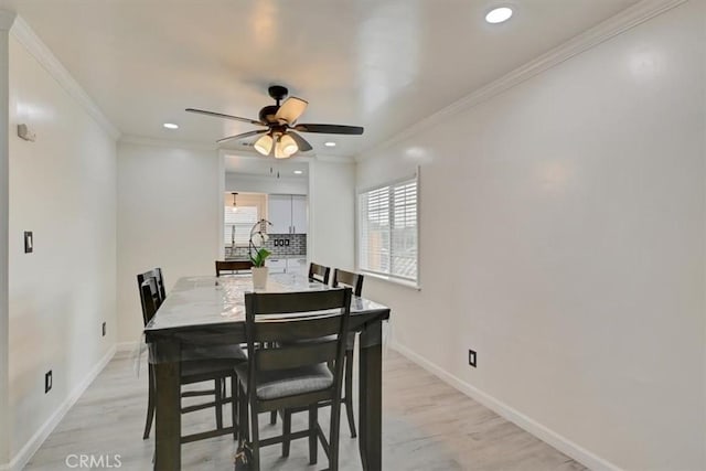 dining space featuring ceiling fan, light hardwood / wood-style floors, and ornamental molding