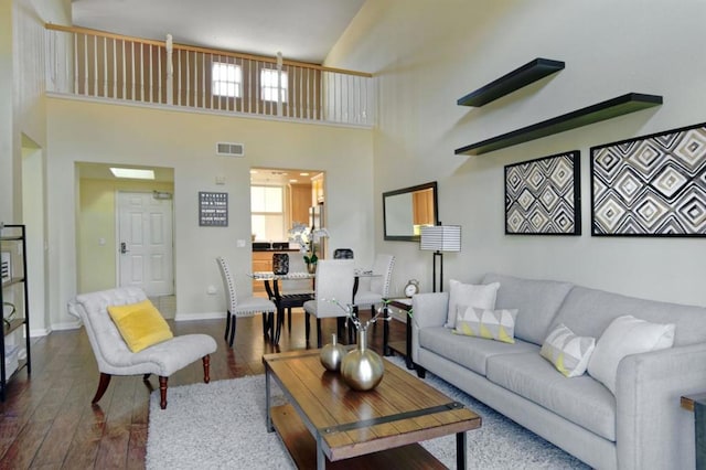 living room featuring a high ceiling and hardwood / wood-style floors