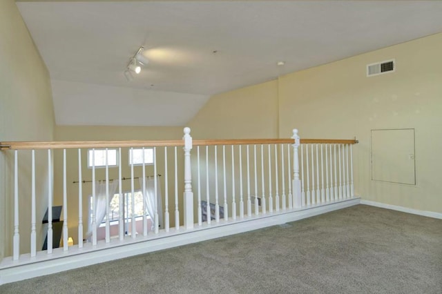 unfurnished room featuring carpet, track lighting, and vaulted ceiling