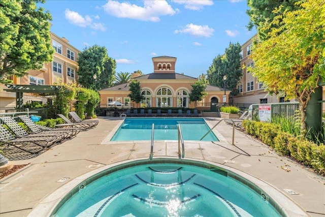 view of swimming pool with a hot tub