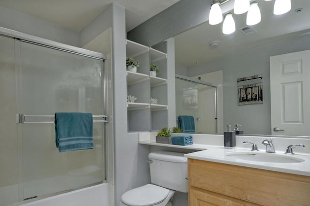 full bathroom featuring toilet, vanity, and enclosed tub / shower combo