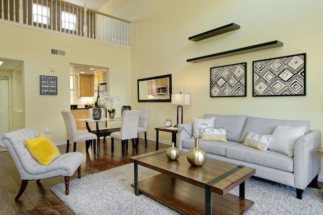 living room with wood-type flooring and a high ceiling