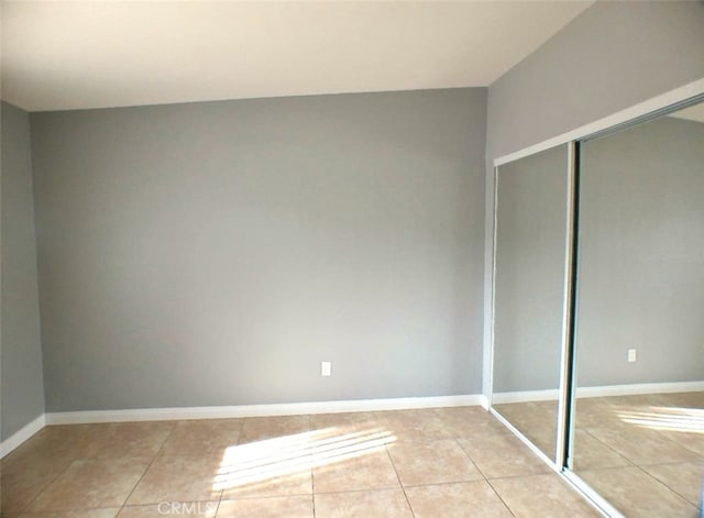 unfurnished bedroom featuring a closet and light tile patterned floors