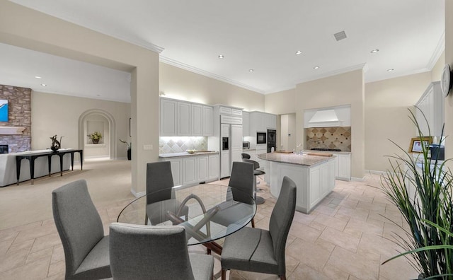 dining area with a fireplace and ornamental molding