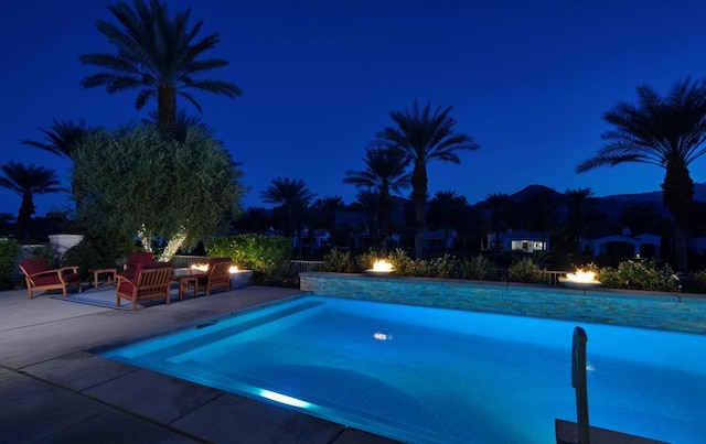 pool at twilight featuring a patio