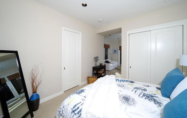 bedroom with light carpet and a closet