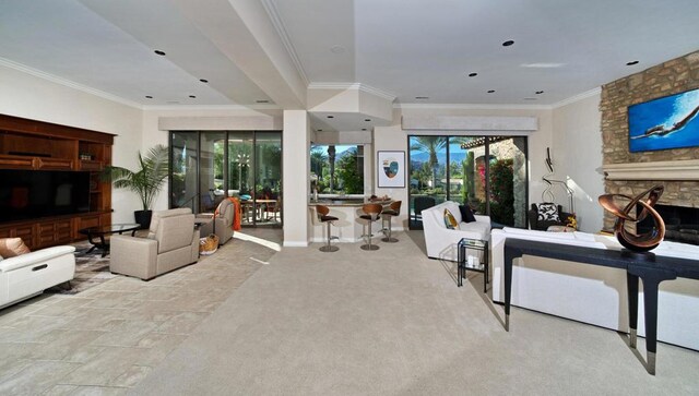 carpeted living room featuring a stone fireplace and ornamental molding