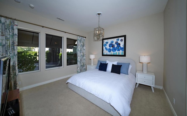 carpeted bedroom featuring an inviting chandelier