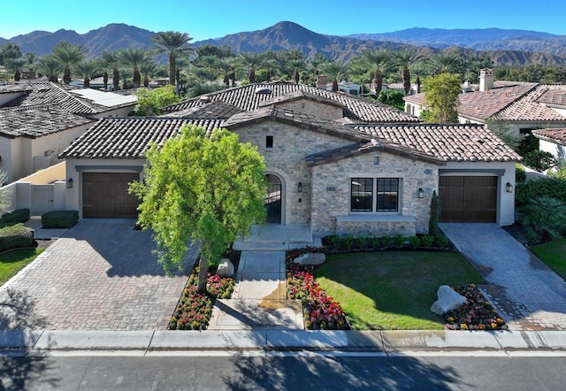 mediterranean / spanish-style house with a mountain view, a garage, and a front lawn