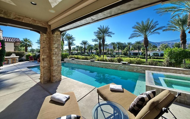 view of swimming pool featuring a mountain view, a patio, and a diving board