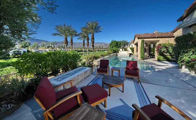 view of patio featuring a mountain view and an outdoor fire pit