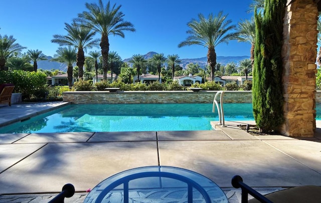 view of swimming pool with a mountain view and a patio