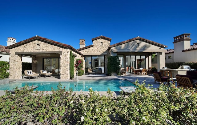 back of house featuring an outdoor kitchen and a patio