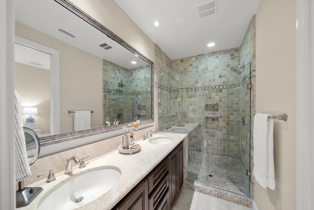 bathroom with tile patterned flooring, vanity, and walk in shower