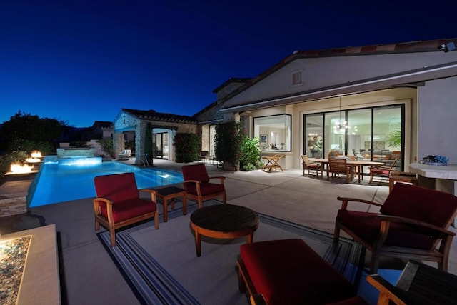 pool at twilight featuring a patio area