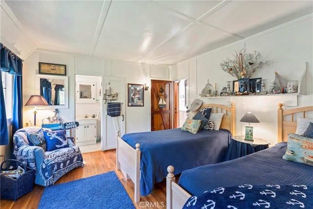 bedroom featuring ensuite bath and hardwood / wood-style floors