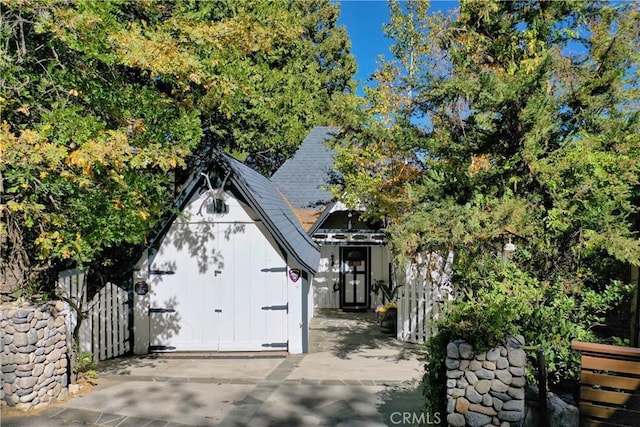 197 Rocky Point Rd, Lake Arrowhead, CA 92352 - view of front facade with a storage shed, board and batten siding, and a shingled roof
