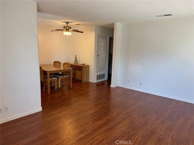 interior space with a textured ceiling, dark hardwood / wood-style floors, and ceiling fan