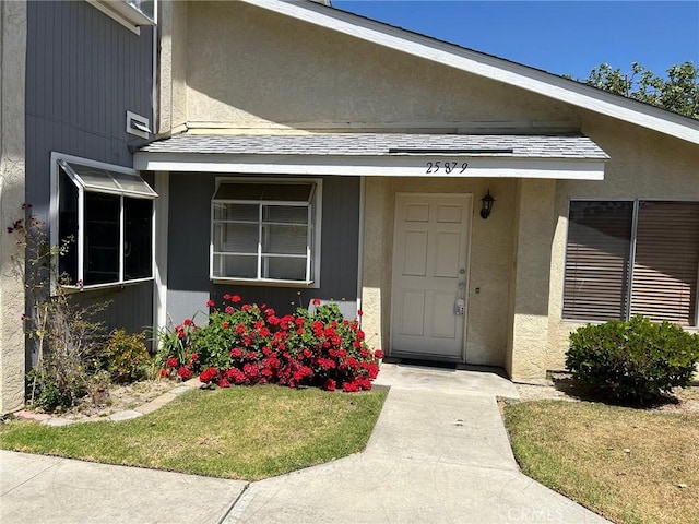 entrance to property with a lawn