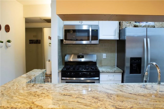 18645 Hatteras St Unit 186, Tarzana, CA 91356 - kitchen featuring stainless steel appliances, white cabinetry, backsplash, and light stone countertops