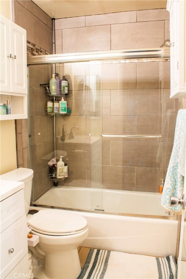 full bathroom with vanity, toilet, and enclosed tub / shower combo