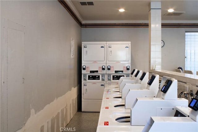 laundry room with crown molding and stacked washer and clothes dryer