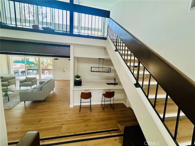 18645 Hatteras St Unit 186, Tarzana, CA 91356 - staircase with hardwood / wood-style flooring and a high ceiling