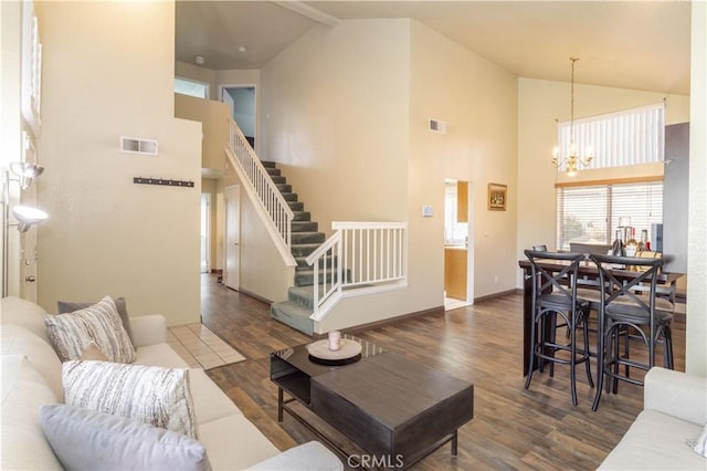 living room featuring a chandelier, beam ceiling, high vaulted ceiling, and dark wood-type flooring