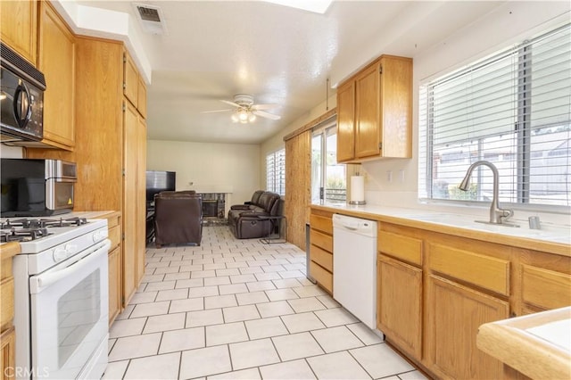 kitchen with ceiling fan, sink, light tile patterned floors, and white appliances