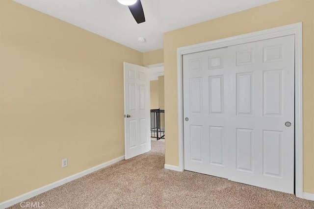 unfurnished bedroom with light colored carpet, a closet, and ceiling fan