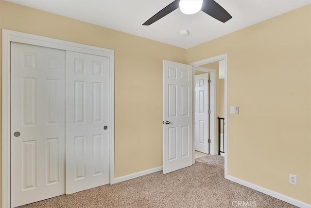 unfurnished bedroom with ceiling fan, a closet, and light colored carpet