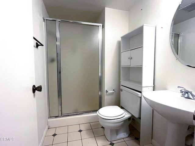 bathroom featuring toilet, a shower with door, and sink