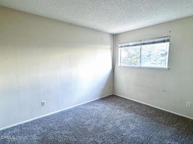 carpeted spare room with a textured ceiling