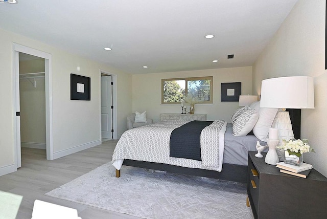 bedroom featuring a closet, a spacious closet, and light hardwood / wood-style flooring