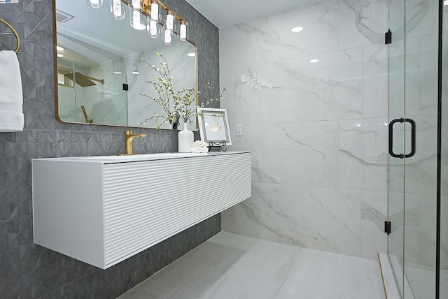 bathroom featuring tile walls, a shower with door, and vanity