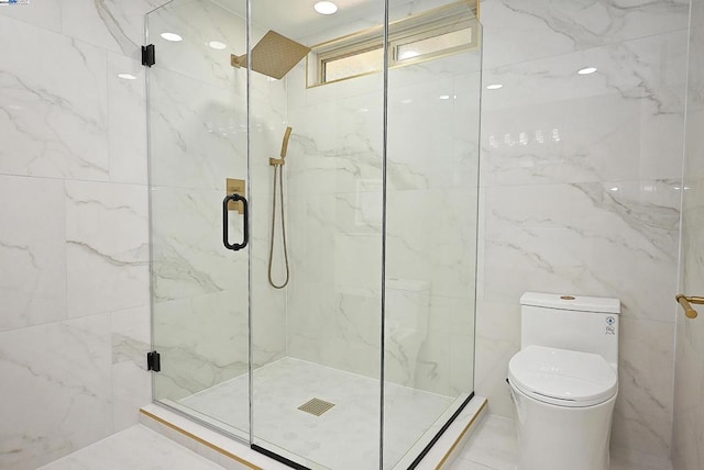 bathroom featuring a shower with shower door and toilet