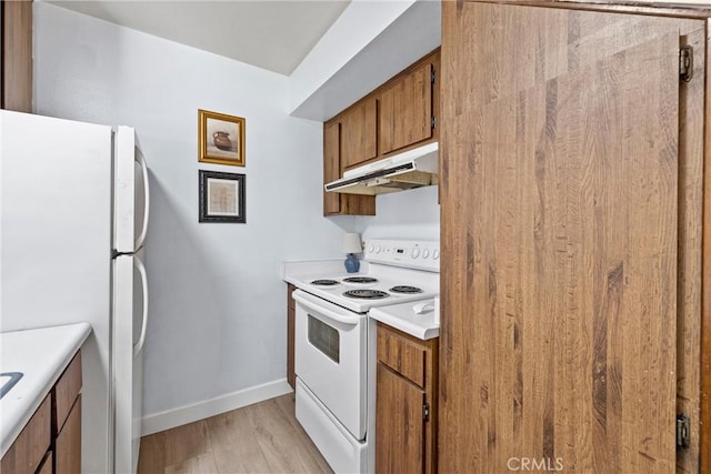 kitchen with light hardwood / wood-style flooring and white appliances