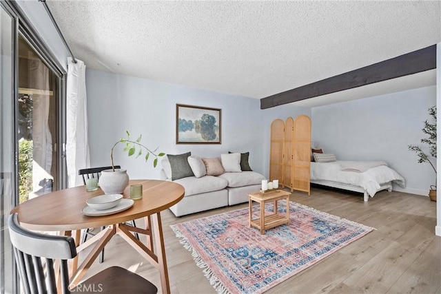 living room with a textured ceiling and light wood-type flooring