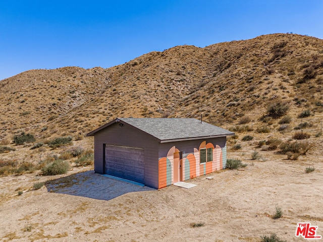 exterior space featuring a mountain view, an outdoor structure, and a garage