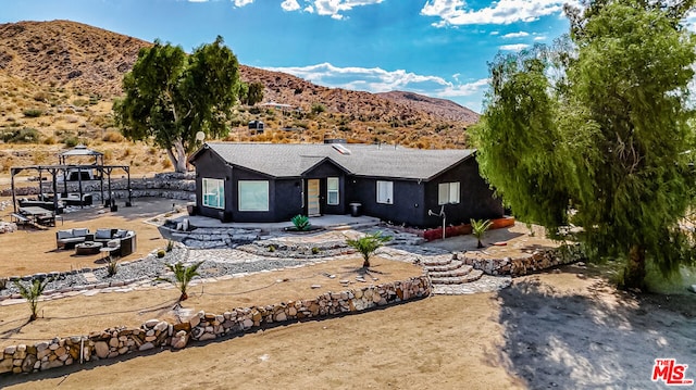 ranch-style house with outdoor lounge area, a mountain view, and a patio area