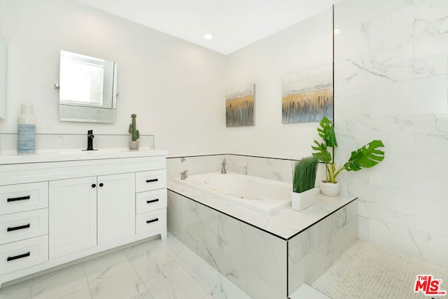 bathroom featuring tiled tub and vanity