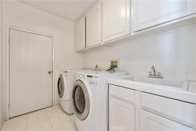 washroom with cabinets, independent washer and dryer, sink, and light tile patterned flooring