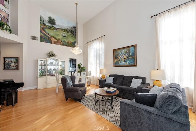 living room with hardwood / wood-style floors, plenty of natural light, and a high ceiling