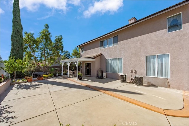 back of property with a pergola, cooling unit, and a patio