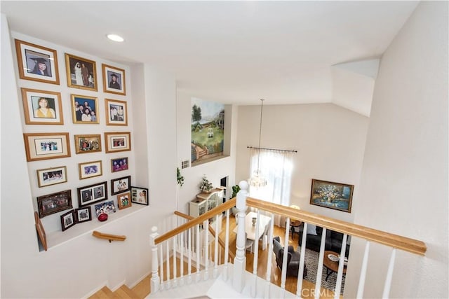 stairway with lofted ceiling and a notable chandelier